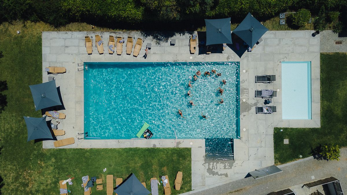 Bird's eye view of a rectangular swimming pool with people enjoying the water.