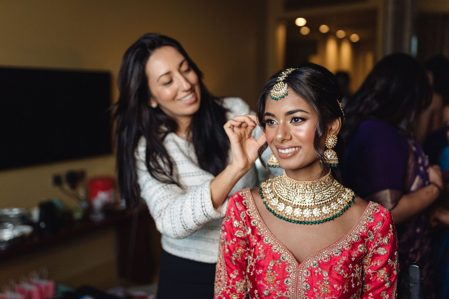 Wedding preparation scene with elegant red and gold traditional Indian attire.