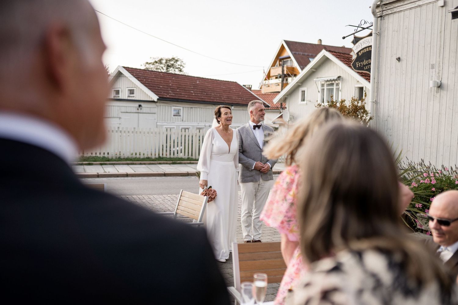 Wedding celebration taking place outdoors with guests watching the festivities.