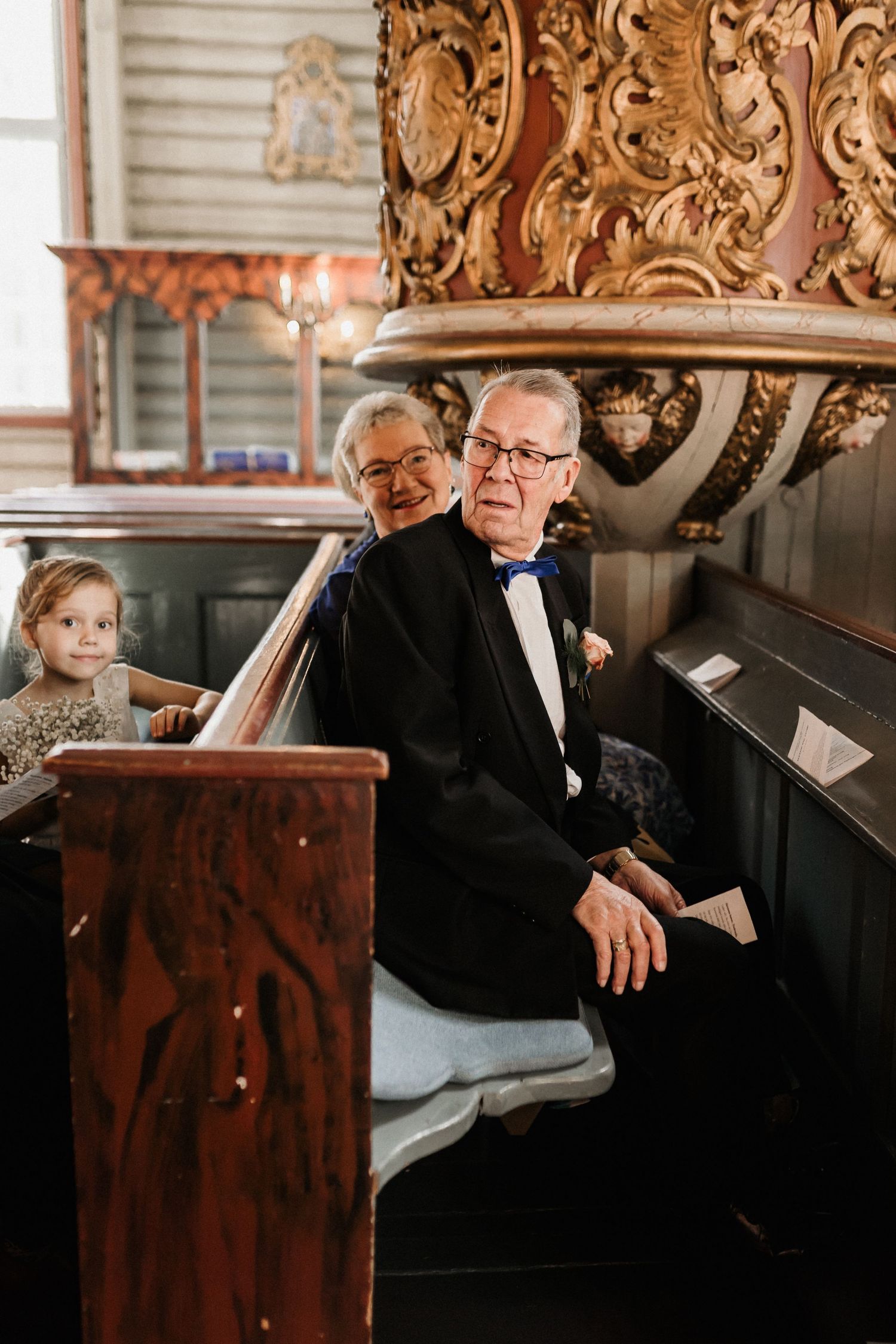 Musicians perform at an ornate wooden piano during a formal church event.