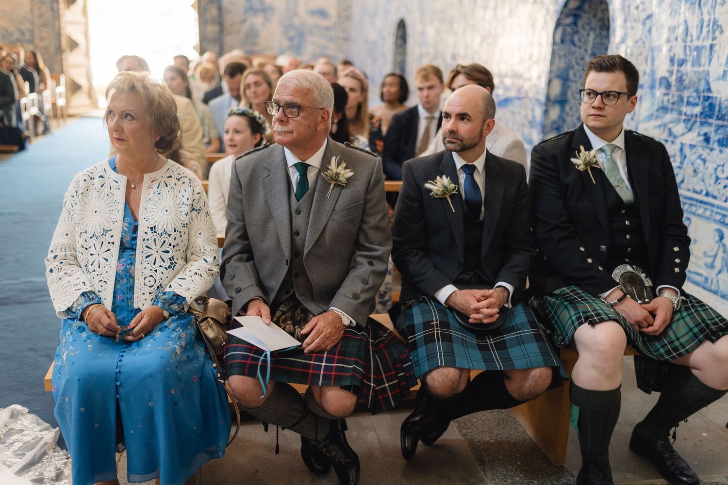 Wedding attendees watching ceremony in historic blue-tiled Portuguese chapel.