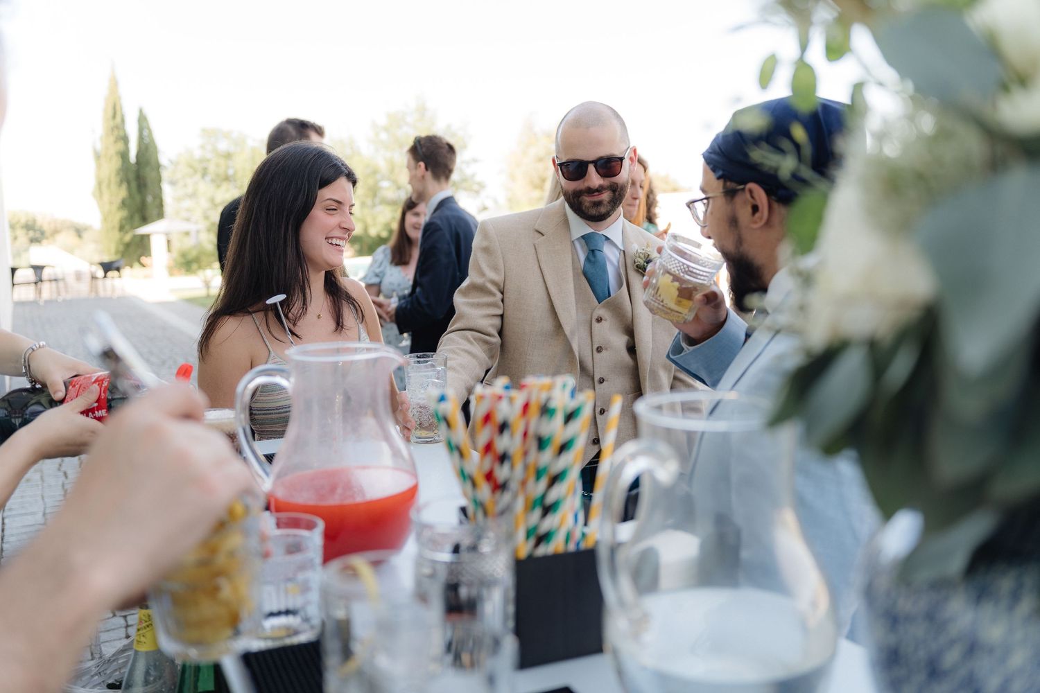 Guests enjoying drinks and conversation at an outdoor wedding celebration.