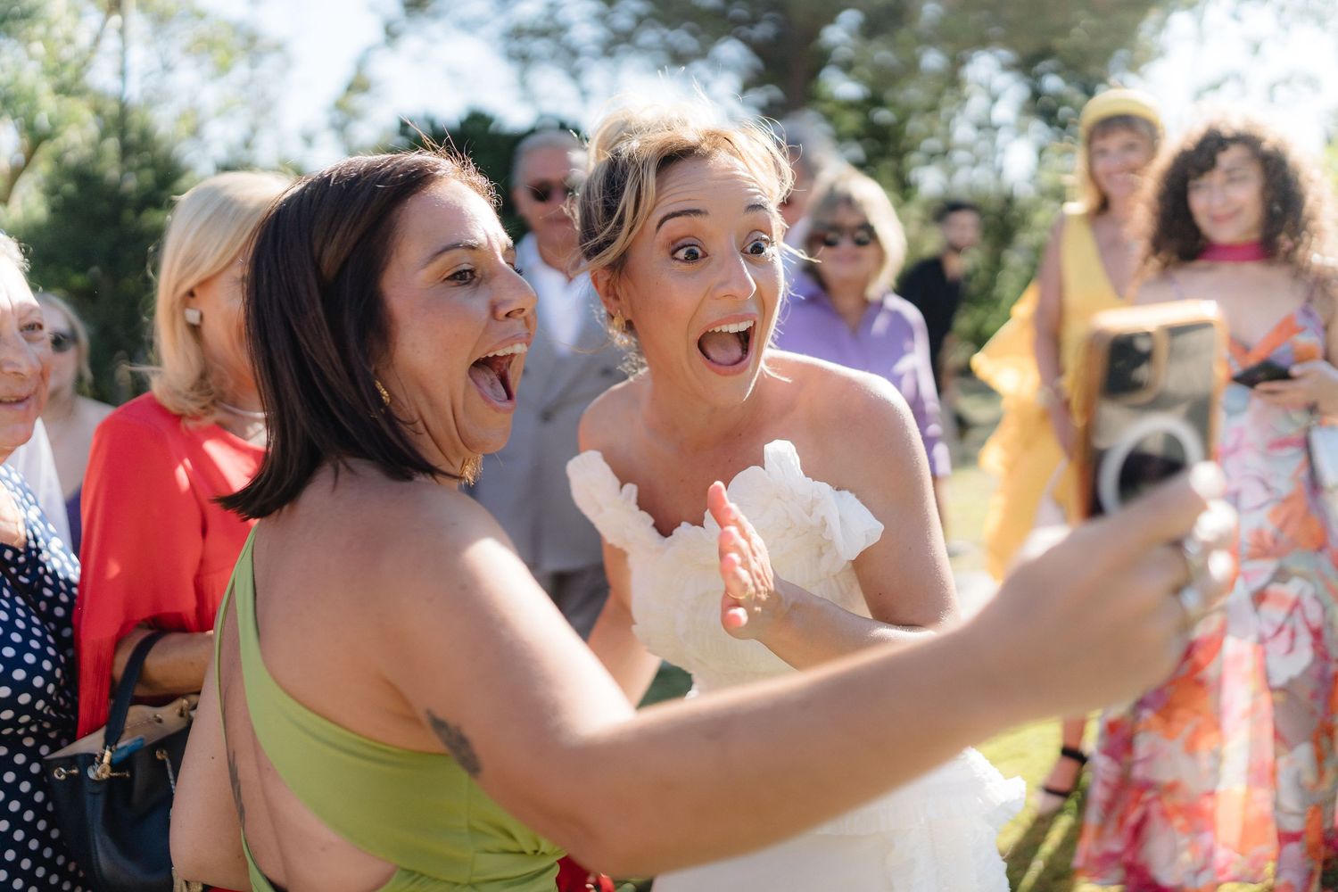 Wedding guests dancing and celebrating with enthusiasm at an outdoor summer party.