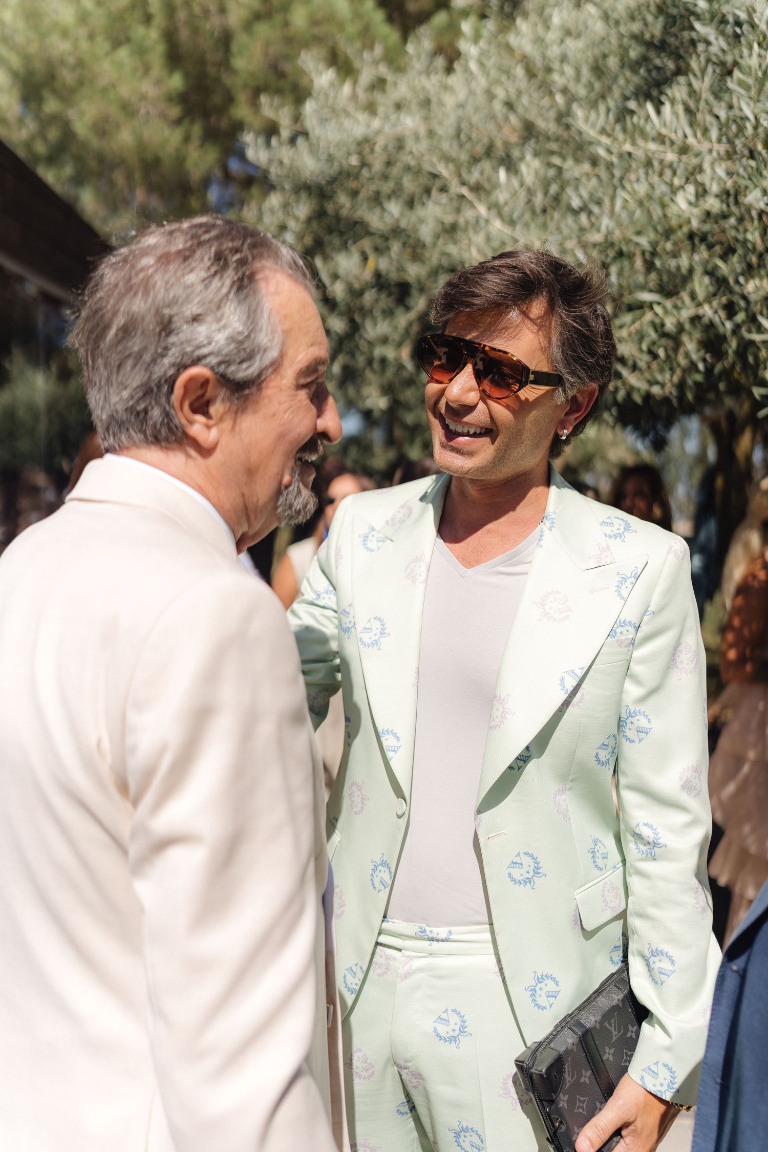 Two people in white jackets sharing a lighthearted moment outdoors.