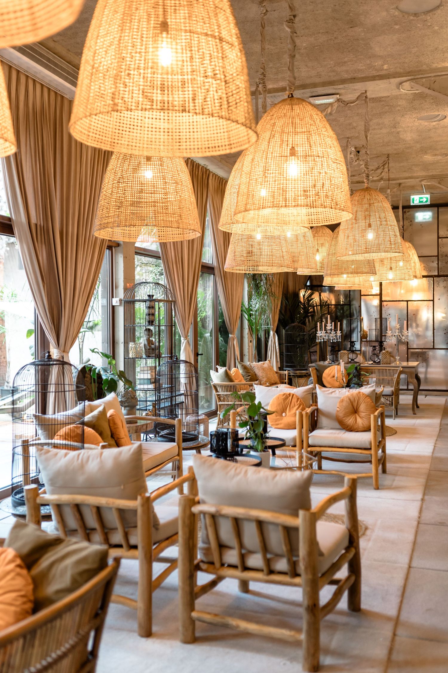 Modern lounge area with rattan pendant lights and comfortable bamboo furniture.