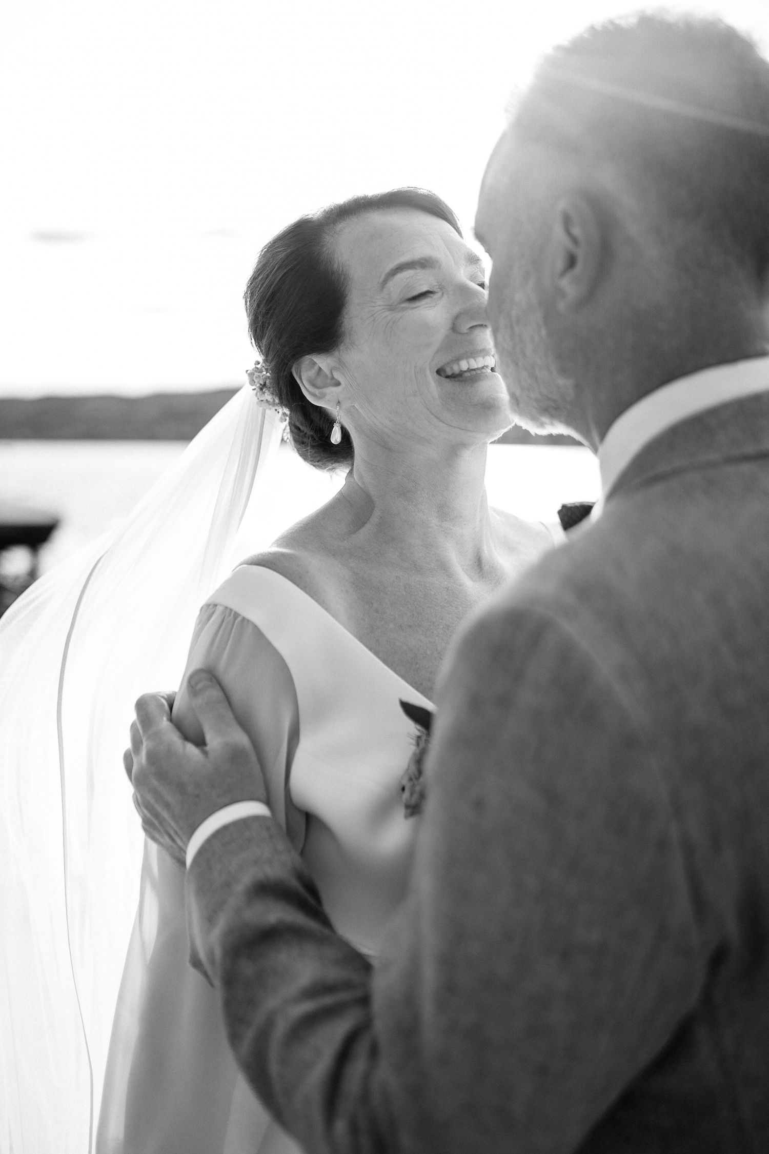 Romantic black and white wedding photography captures an intimate moment between newlyweds.