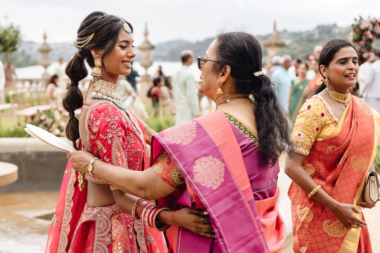Colorful traditional celebration with guests in vibrant saris outdoors.