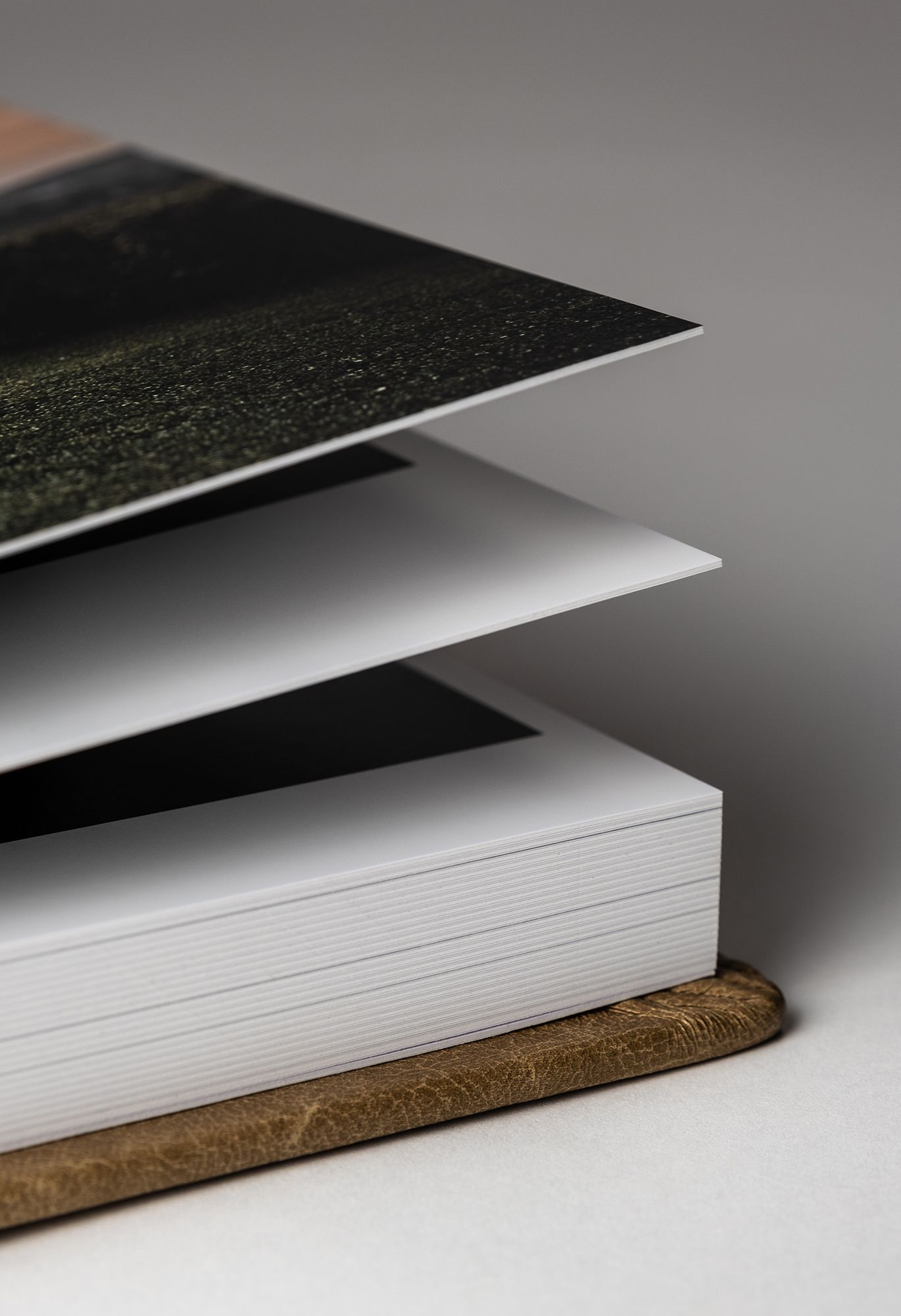 Close-up view of stacked white paper sheets with a dark cover on a wooden surface in minimalist style.