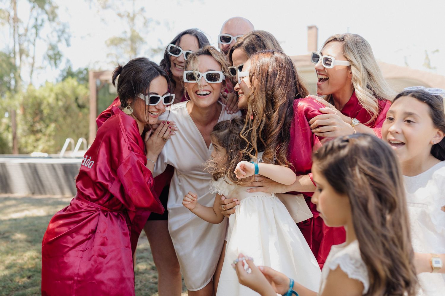 Group enjoying a celebratory moment together by the pool in red and white attire.