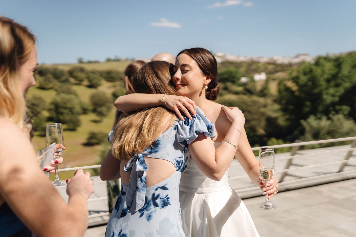Two people share an emotional embrace during an outdoor celebration.