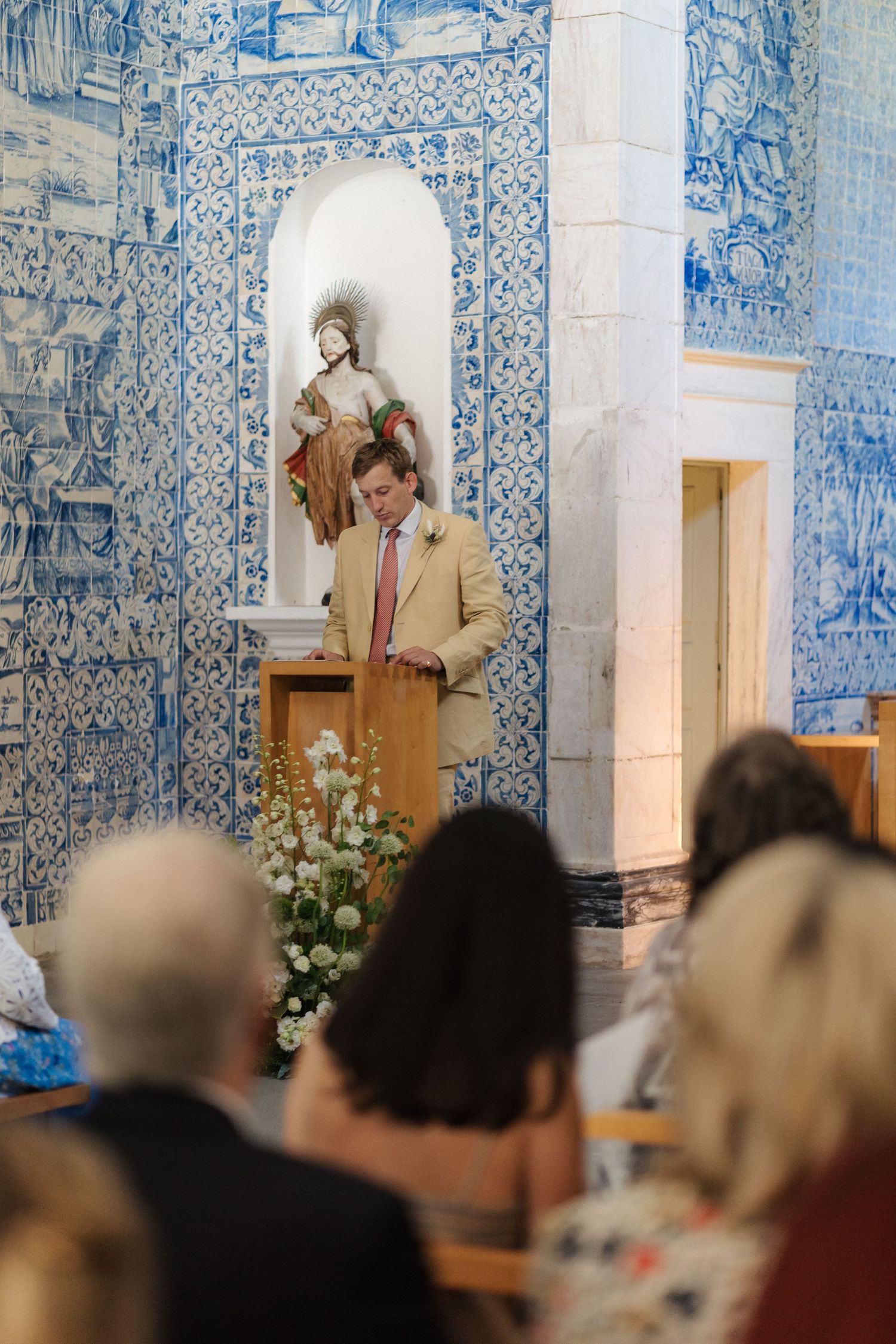 Wedding ceremony in a chapel with beautiful blue and white Portuguese azulejo tile walls.