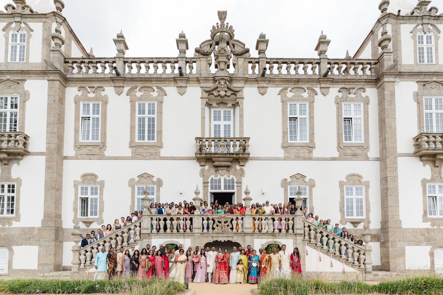 Panoramic view of an ornate European palace facade with classical architecture and statues.