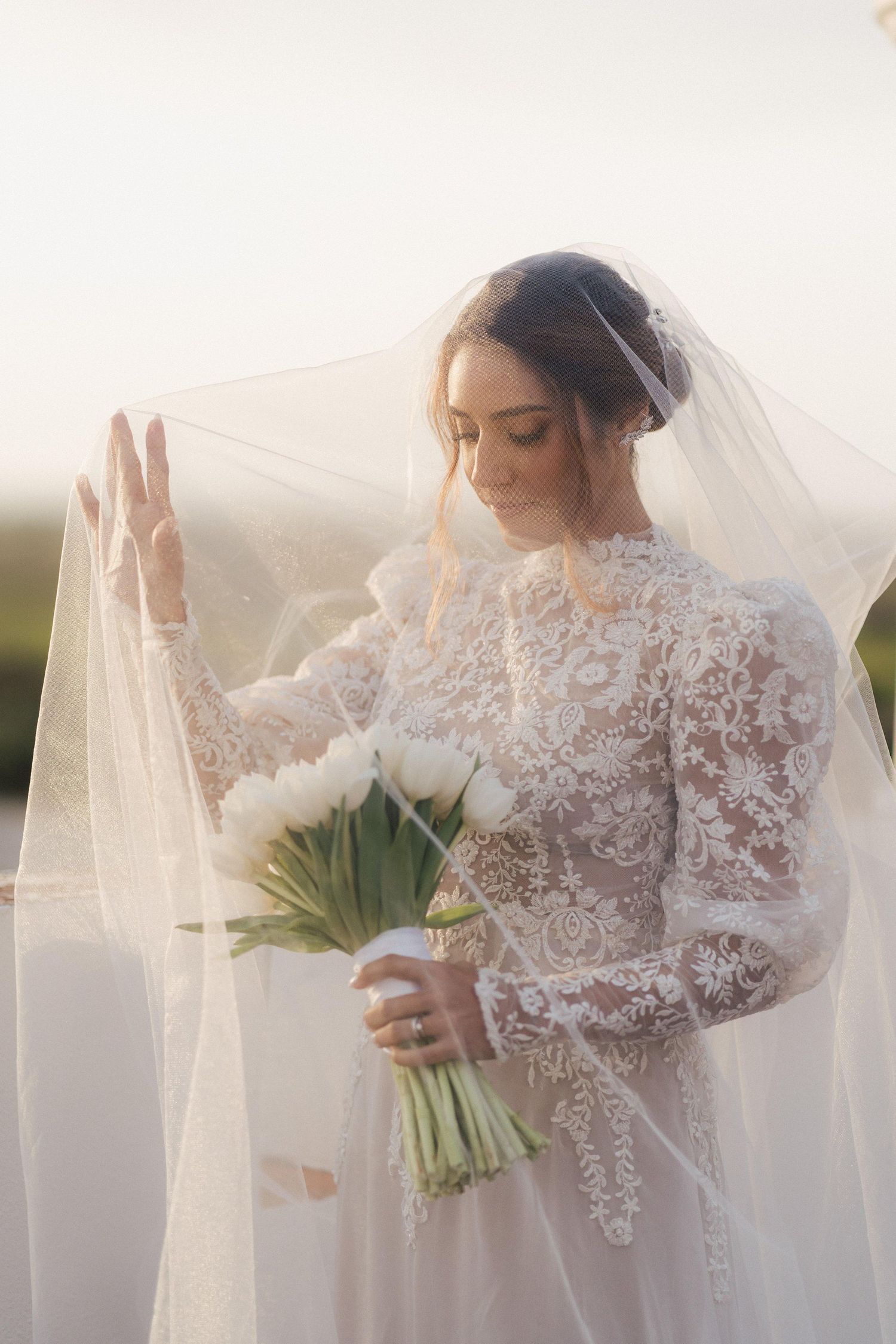 An ethereal bridal portrait series with flowing veil and white floral bouquet.