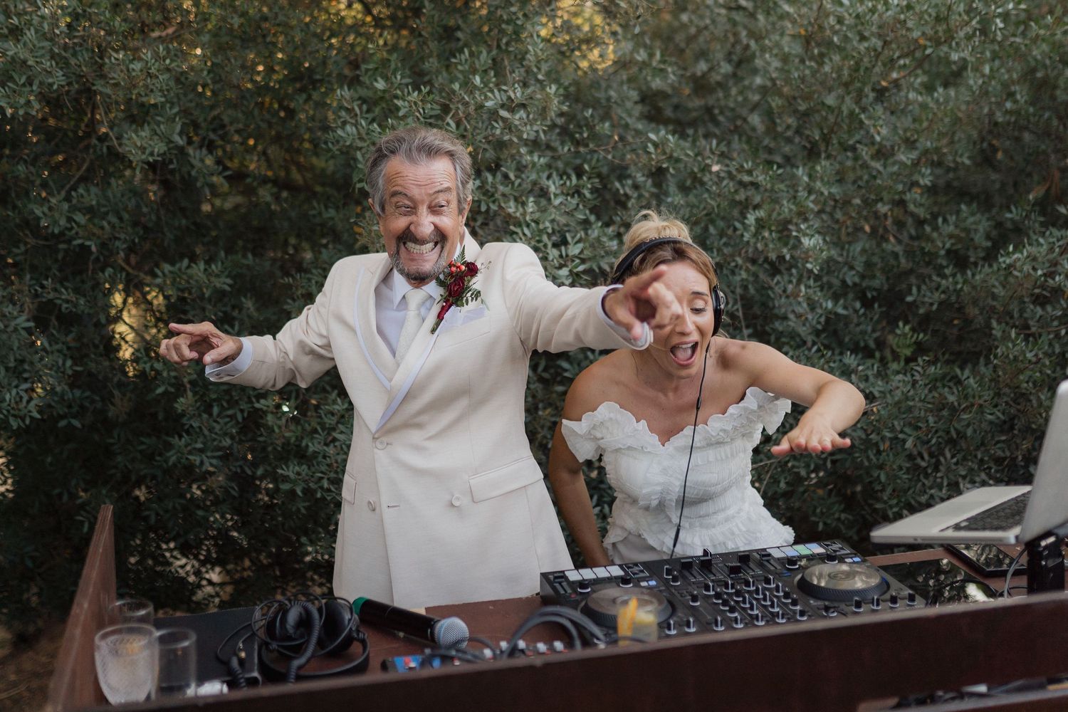 DJs performing at an outdoor wedding reception with professional equipment setup.