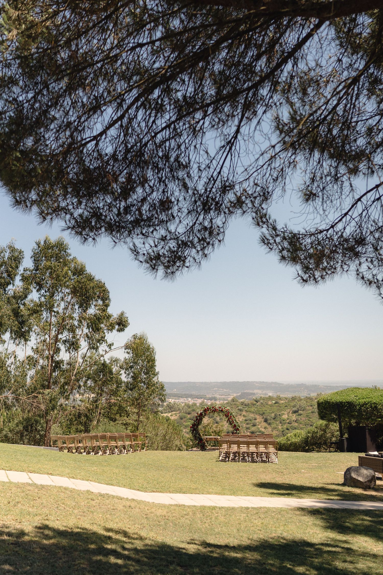 Scenic outdoor wedding venue with rows of chairs overlooking a mountain landscape.