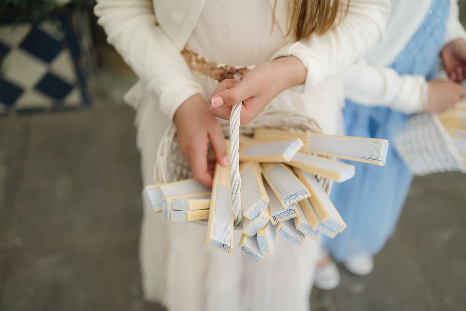 Close-up of hands holding delicate paper items at formal event.