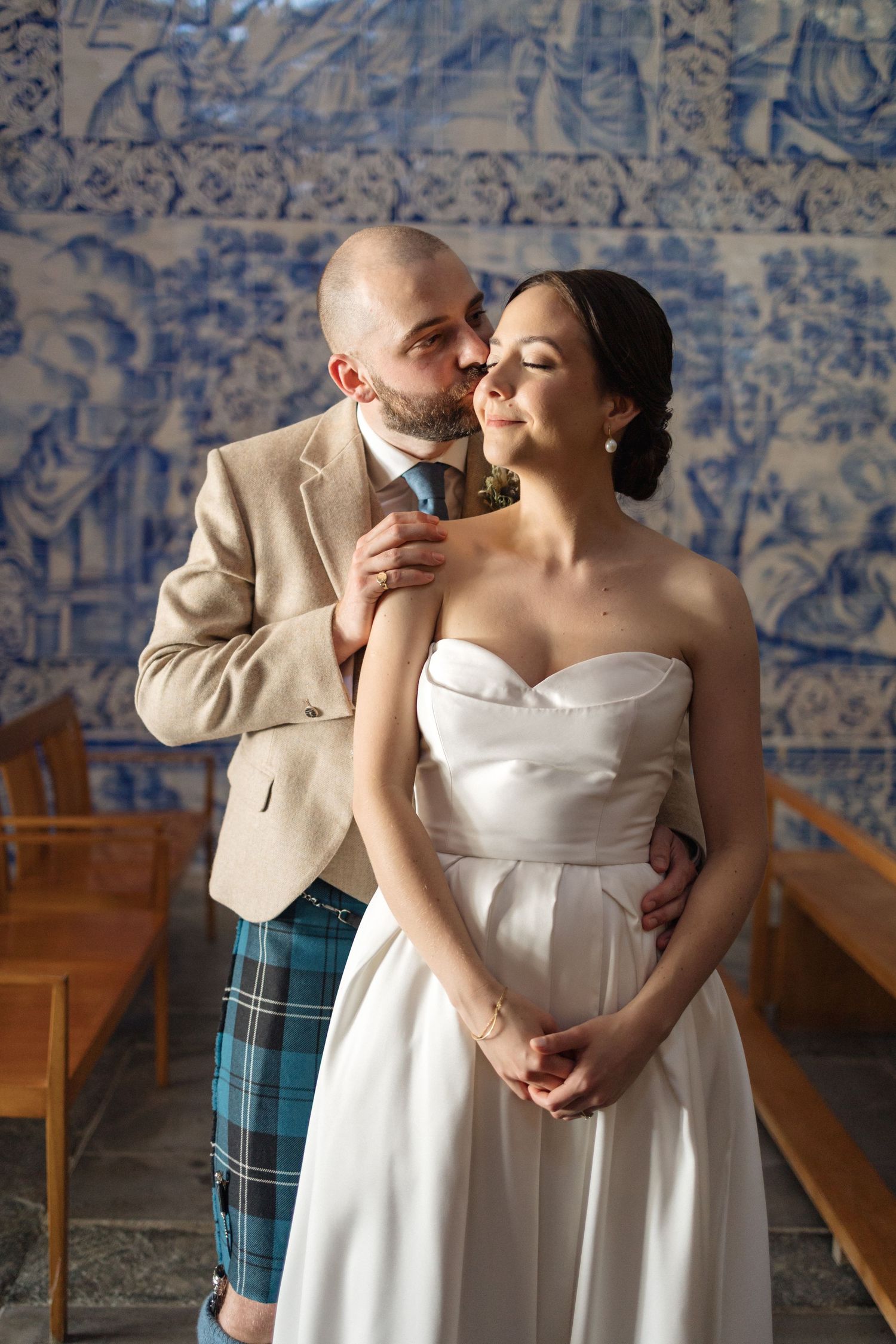 Intimate wedding moments captured against decorative blue tile walls in a historic setting.