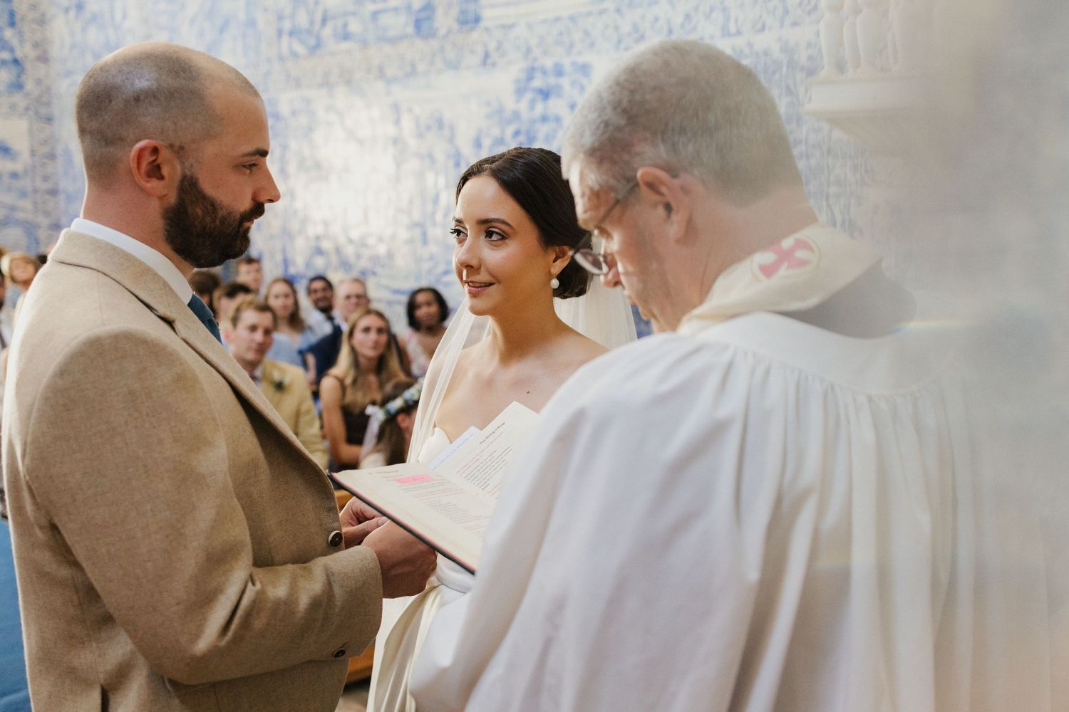 Wedding ceremony in a beautiful blue and white tiled Portuguese church with traditional decor.