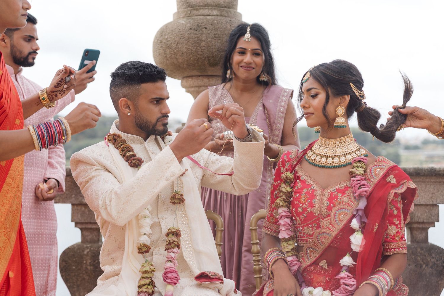 Candid moments from an Indian wedding ceremony with guests in traditional attire at an outdoor venue.