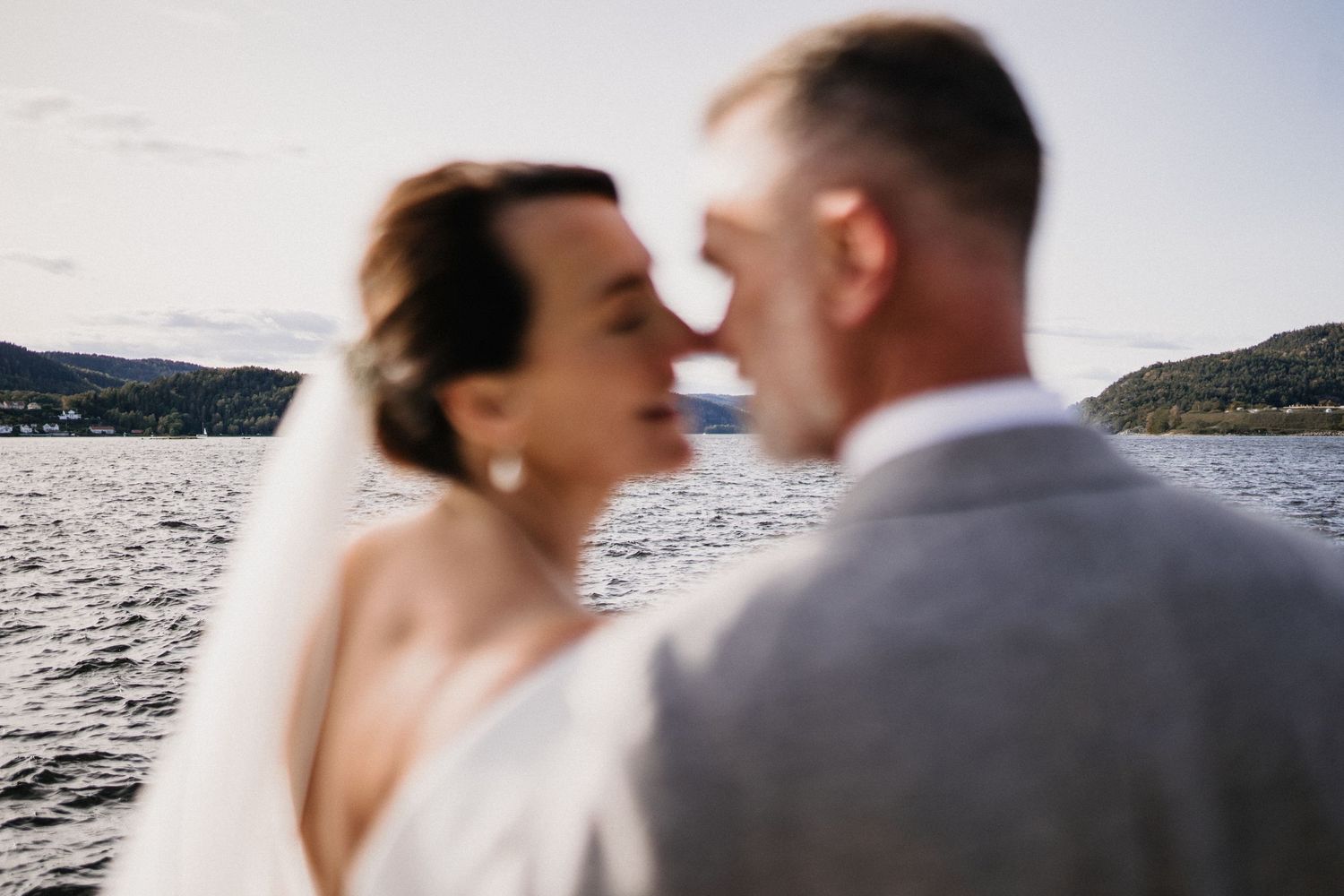 Romantic lakeside wedding portraits with water and mountains in the background.