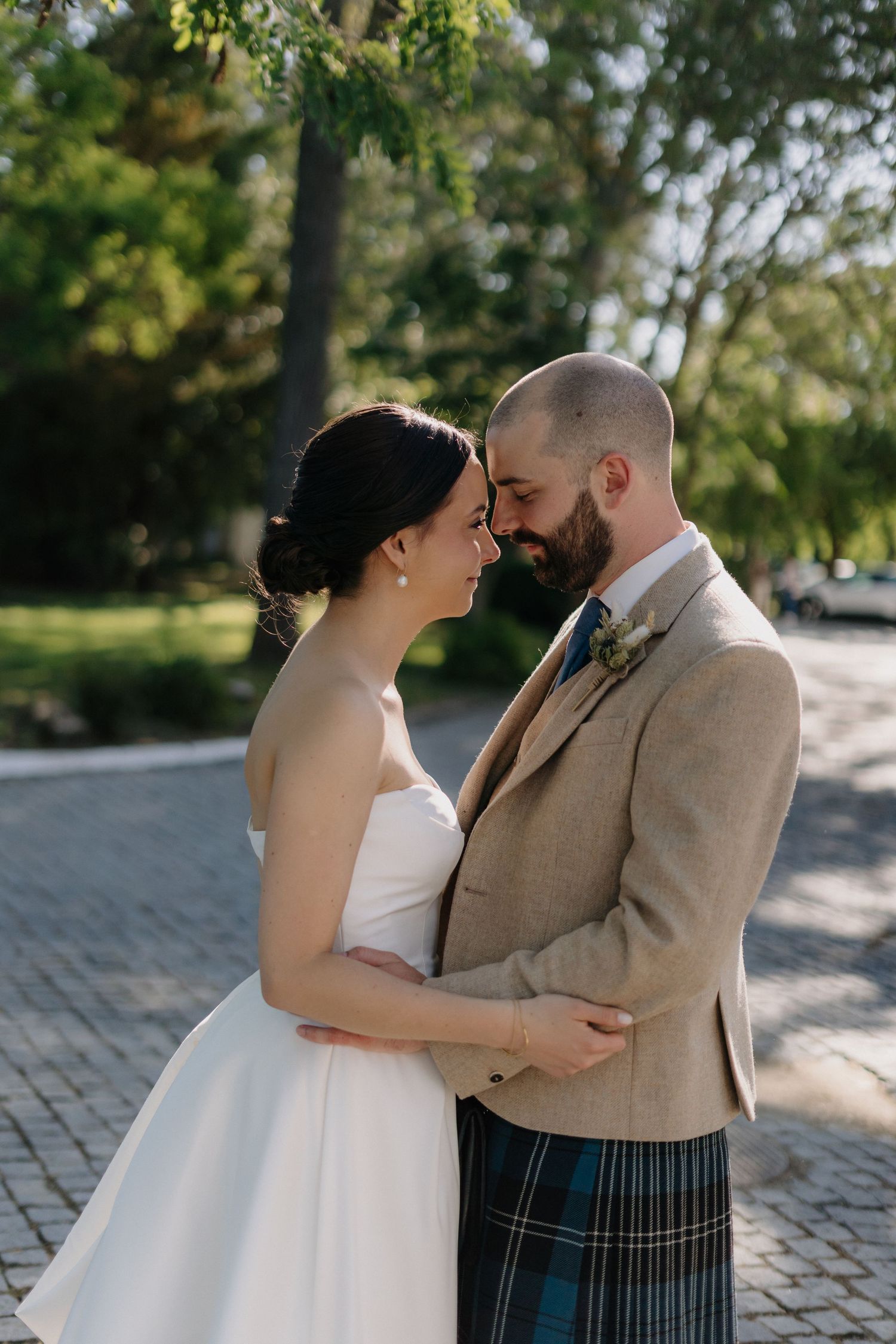 A romantic wedding photoshoot sequence showing a couple embracing on a cobblestone path.