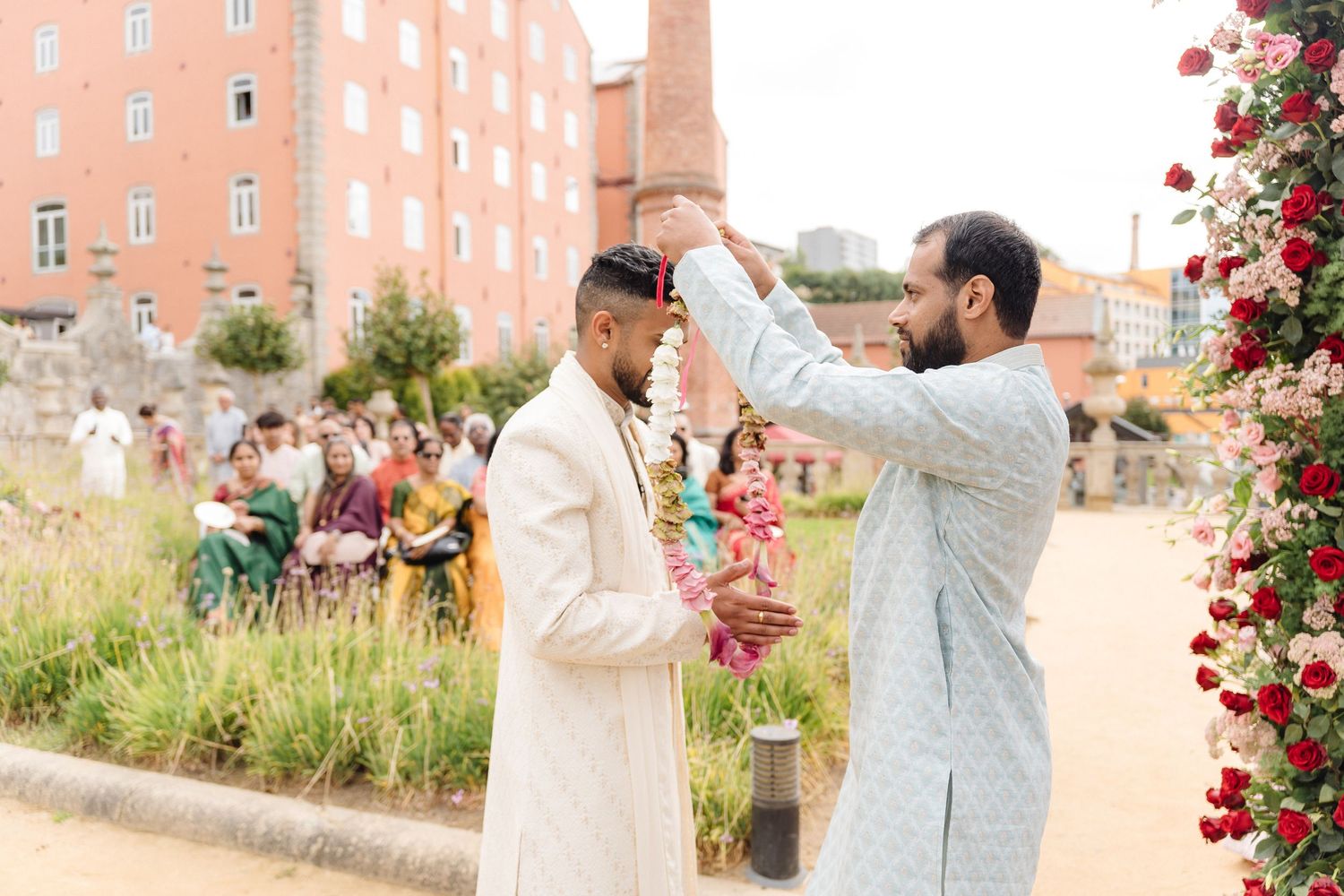 Traditional ceremony taking place outdoors with decorative floral arrangements.