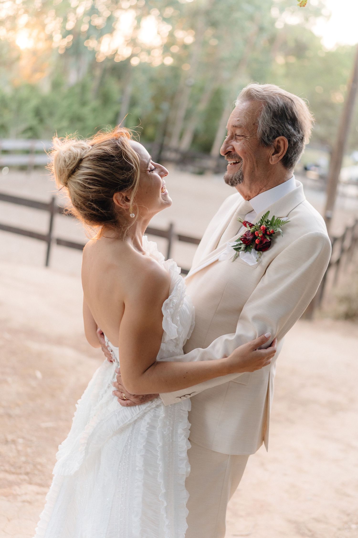 A couple shares a joyful moment together during their outdoor wedding ceremony in natural lighting.