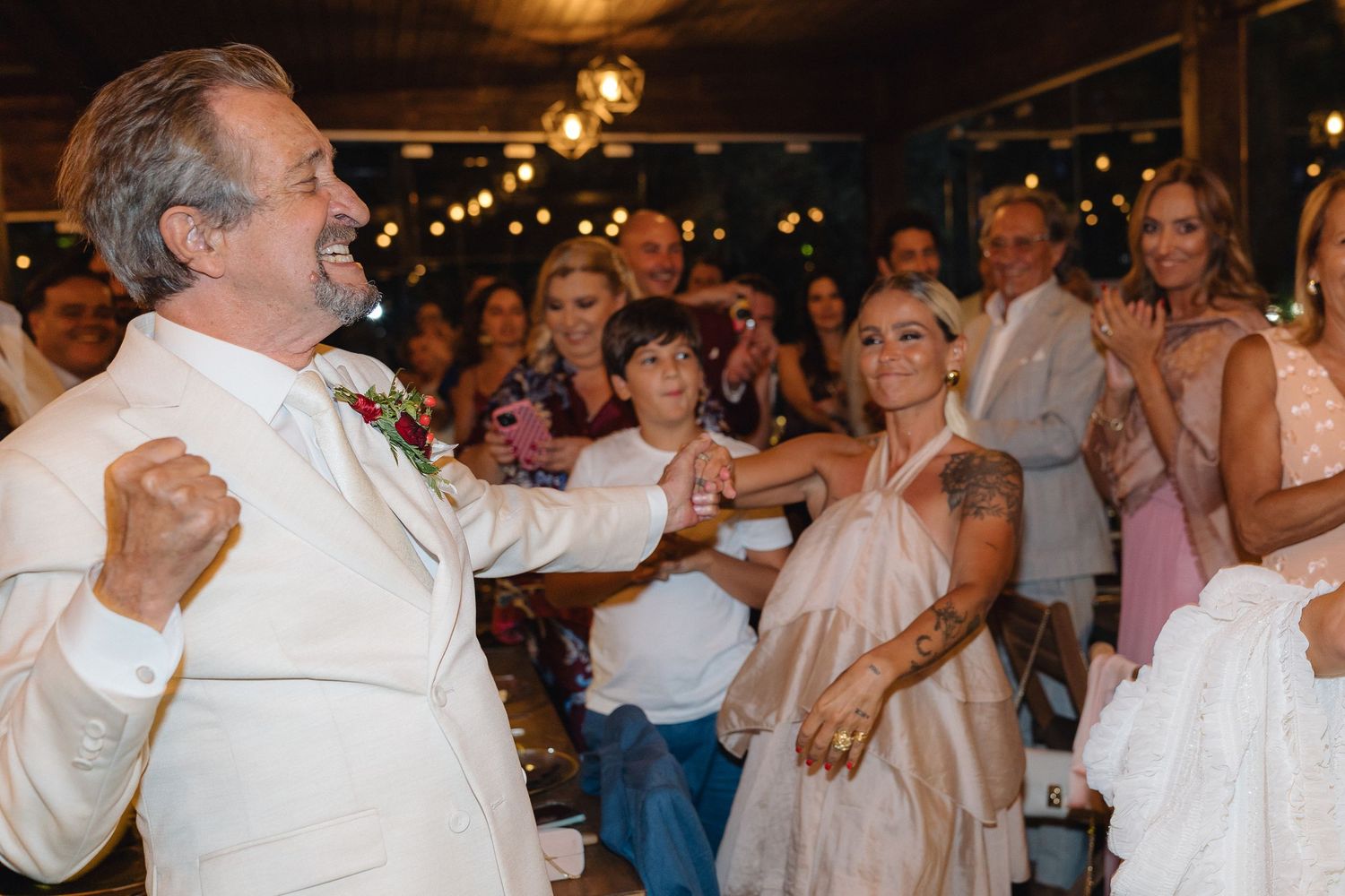 Joyful dancing and celebration at a wedding reception with guests in formal attire.