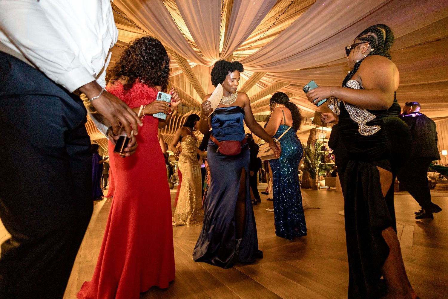 Wedding guests dancing and celebrating on a decorated dance floor at an indoor reception.