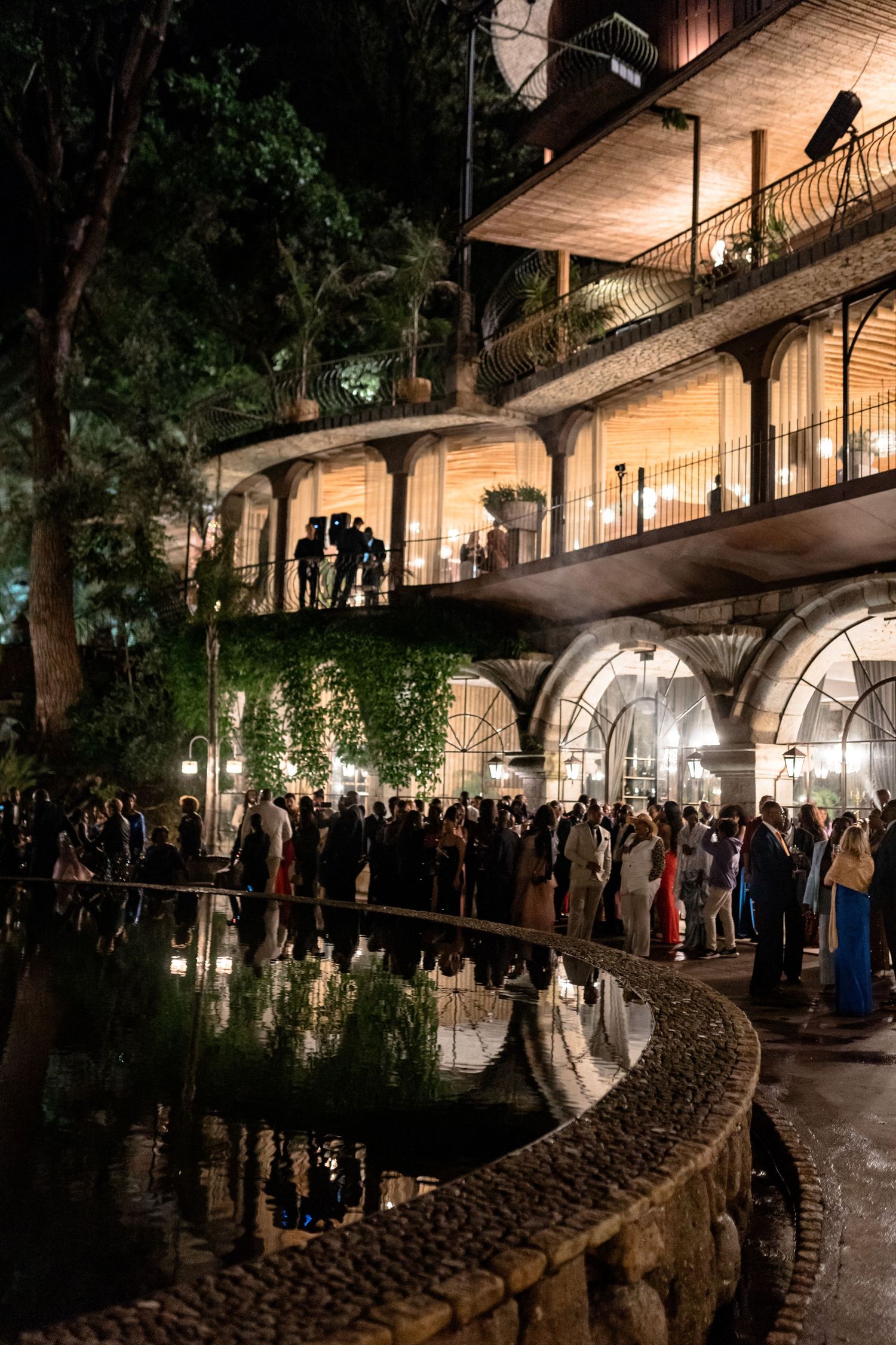 Evening wedding reception at historic venue with arched walkways and ambient lighting.