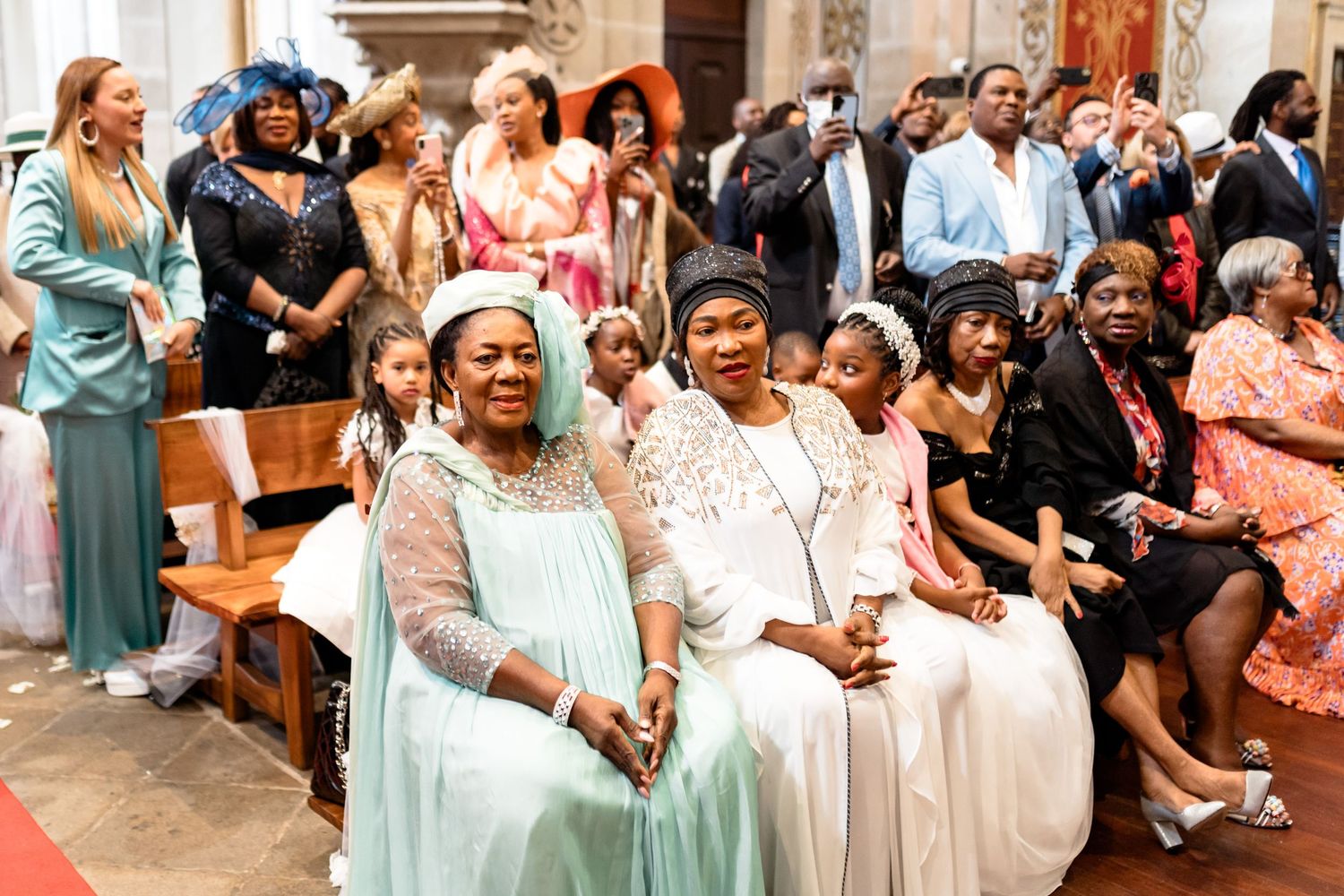 Wedding guests seated in church pews during an emotional ceremony moment.