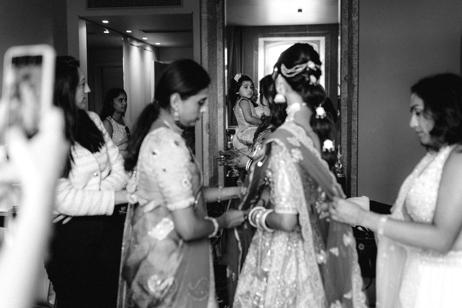 Wedding preparation scene with people getting ready in a dimly lit room.
