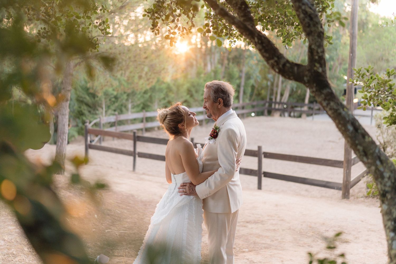 Newlyweds share an intimate moment walking together in a garden setting at golden hour.