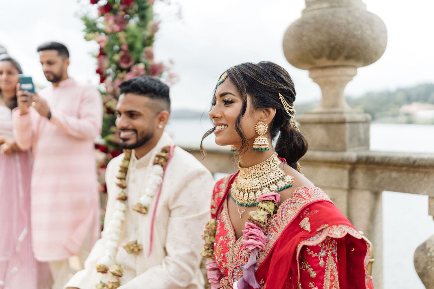 Traditional wedding celebration with decorative red roses and stone architecture.