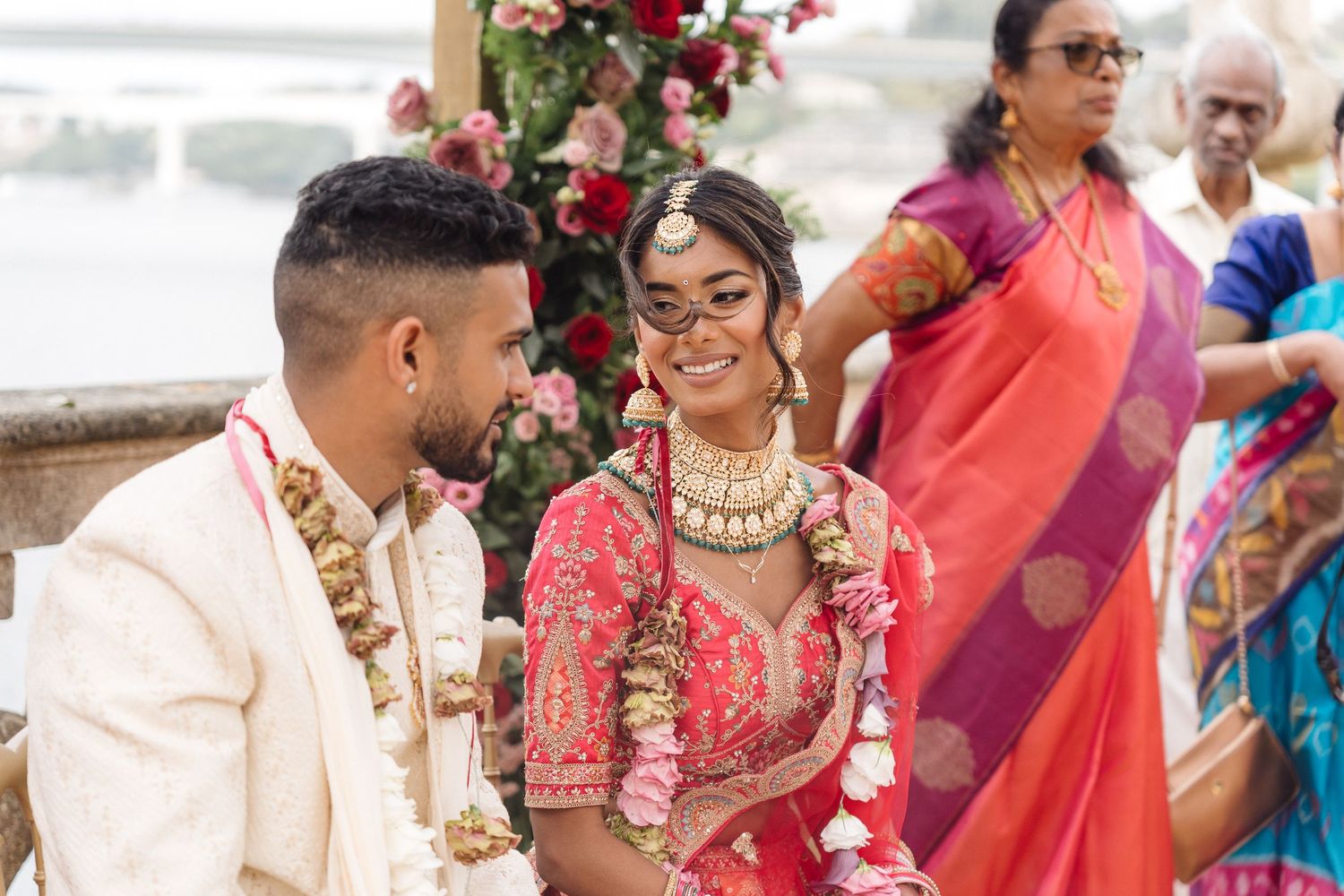 Wedding celebration outdoors with guests in traditional Indian formal wear.