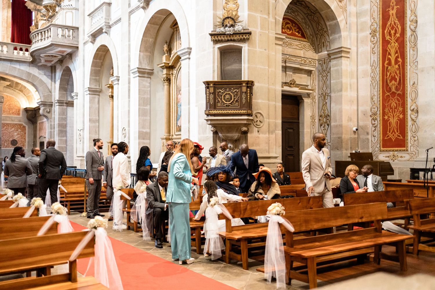 Interior of a grand cathedral with wooden pews and ornate architectural details.