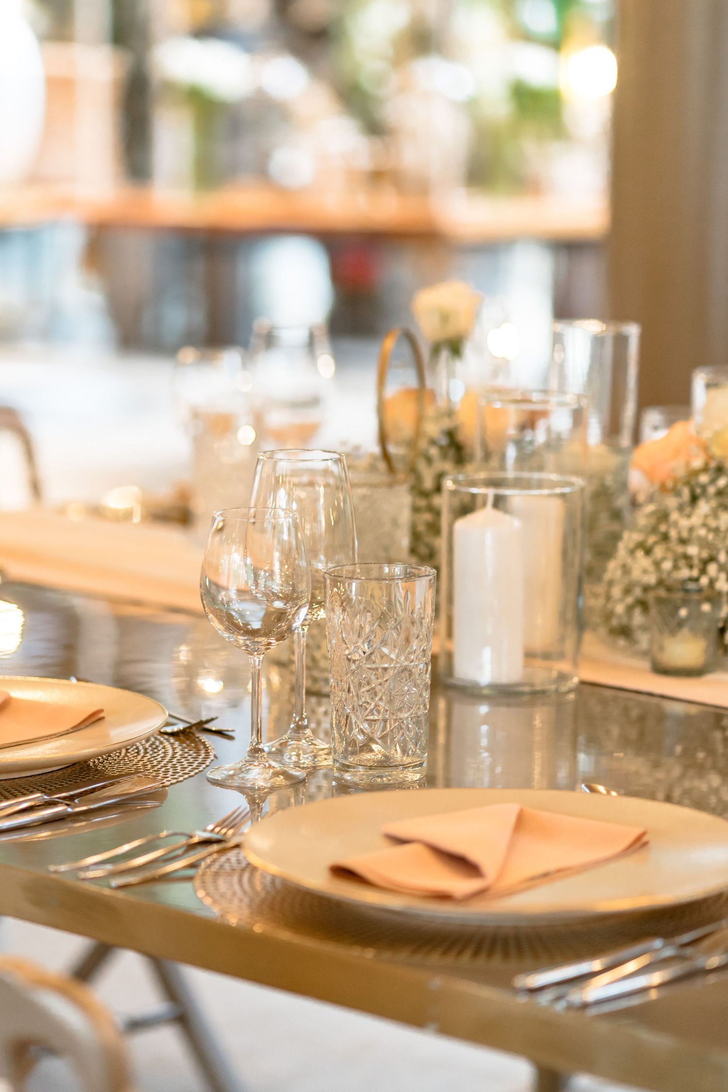 Luxurious table setting with gold charger plates, crystal glassware and white candles.