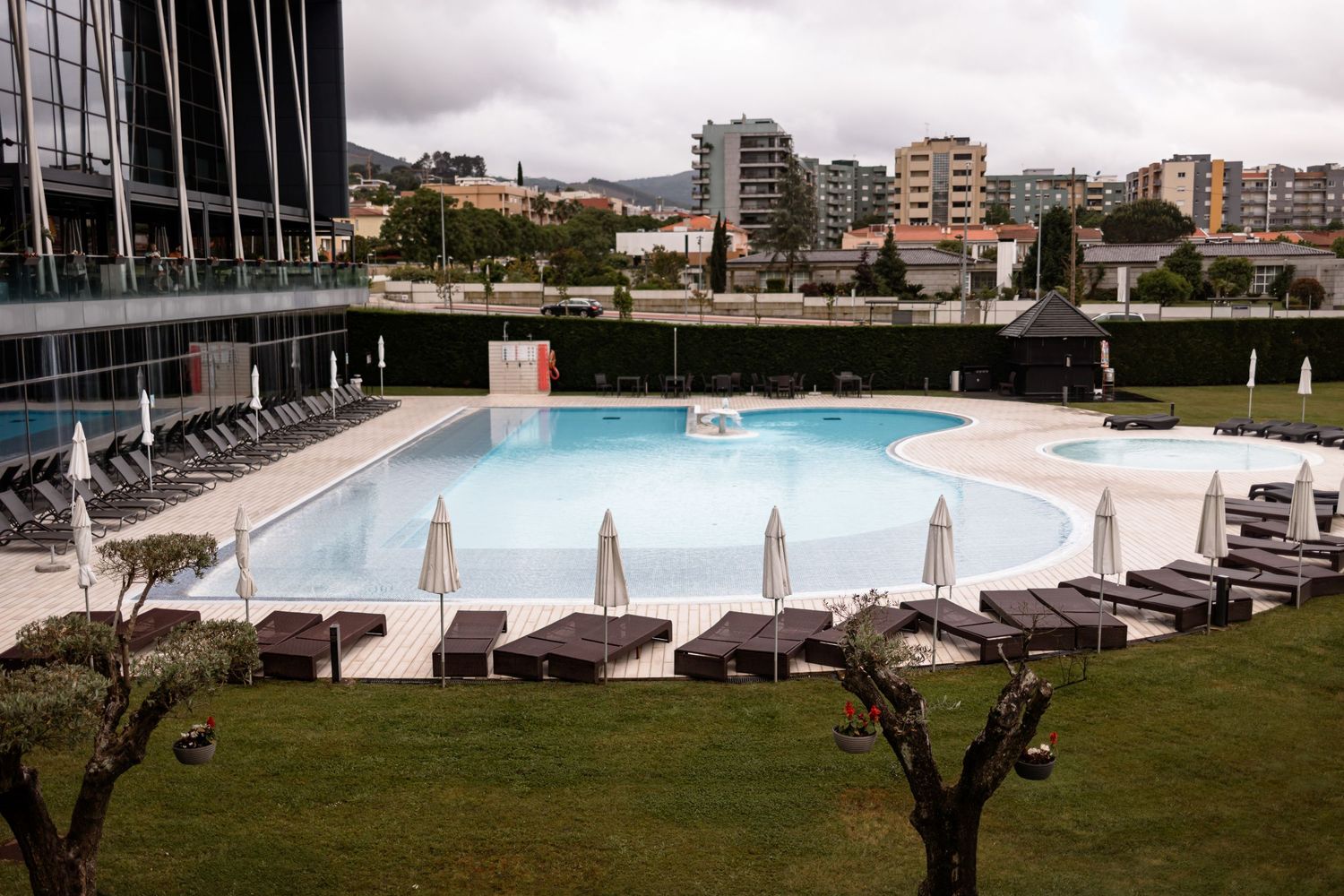 Luxurious outdoor swimming pool area with lounge chairs and umbrellas at an upscale resort venue.