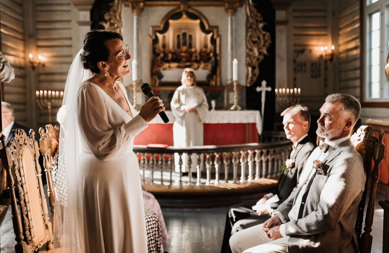 A historic church interior with elegant chandeliers and traditional wooden details.