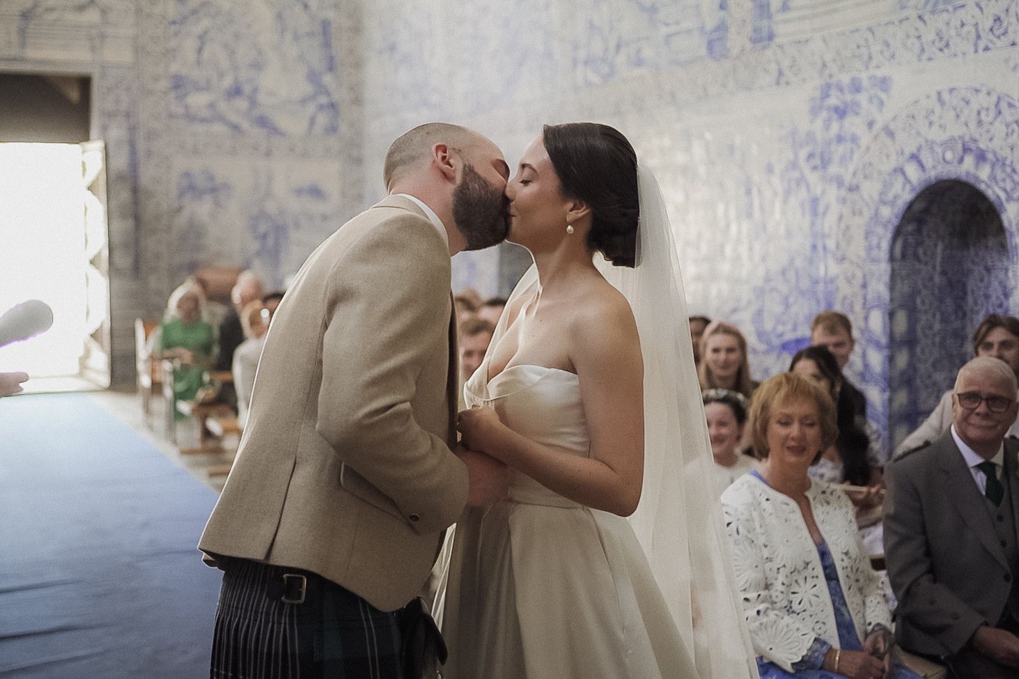 Intimate wedding moment in ornate Portuguese chapel with blue tile murals.