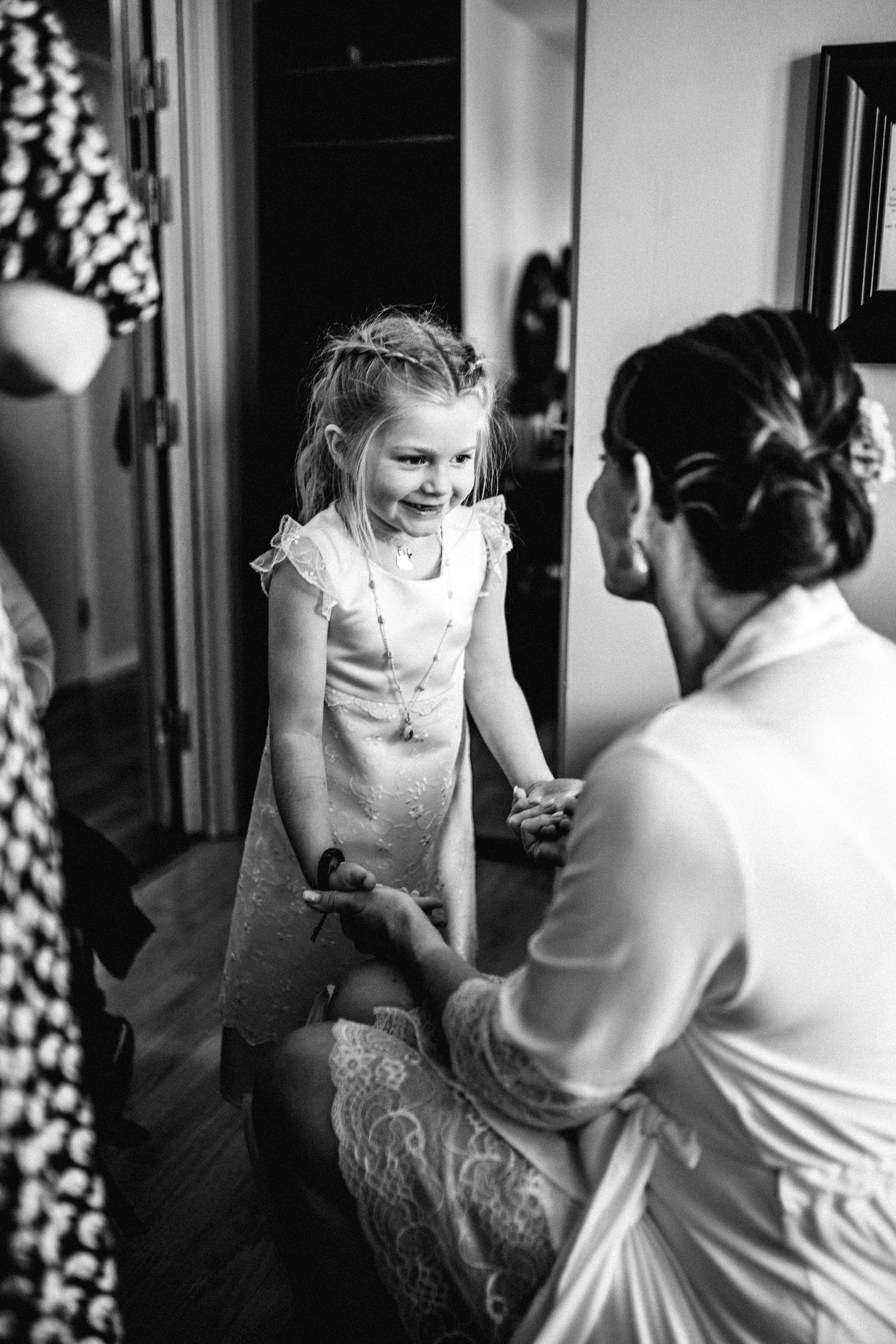 Black and white photograph showing intimate moments during preparation.