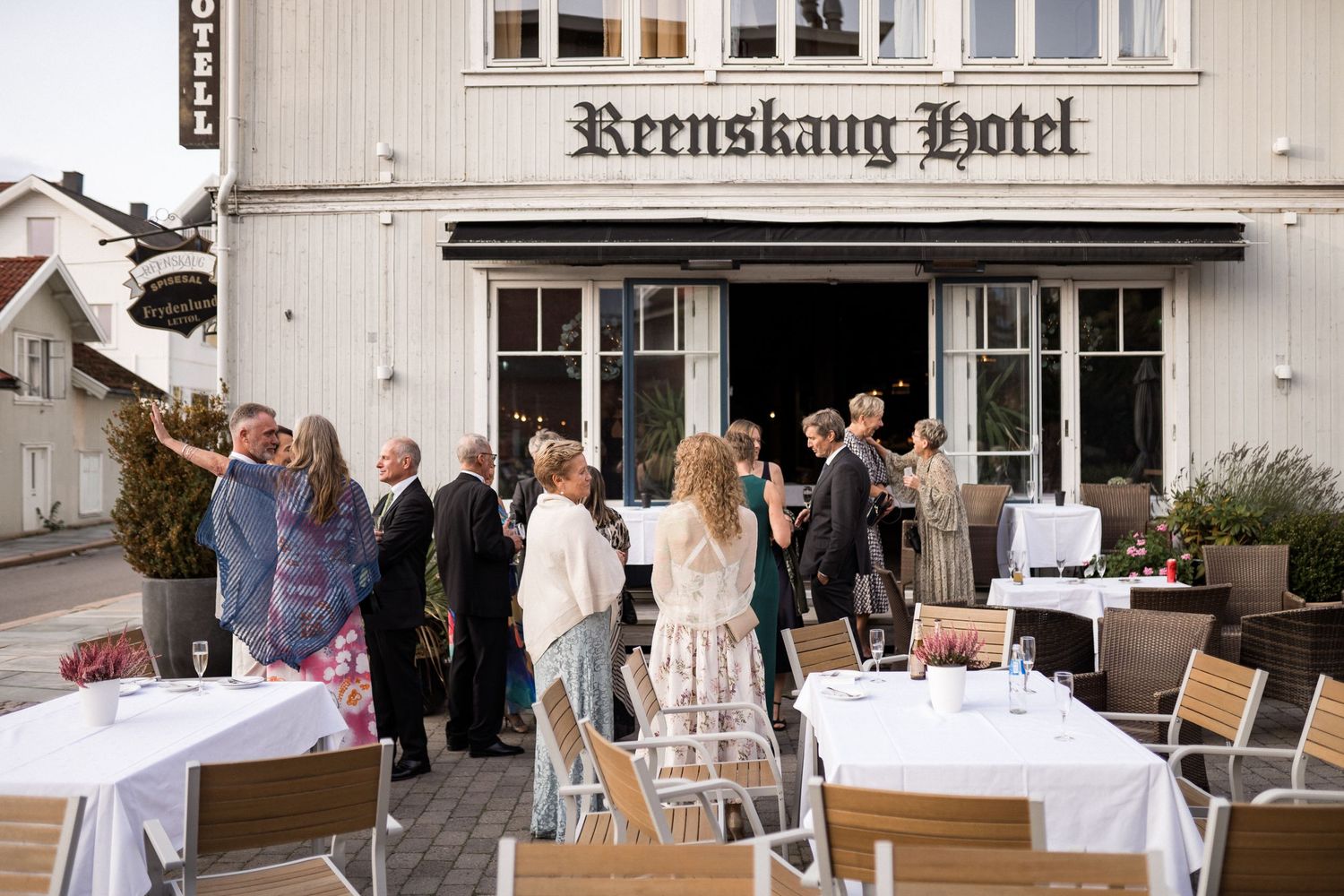 Exterior view of Krenkshang Hotel with white facade and outdoor dining setup.