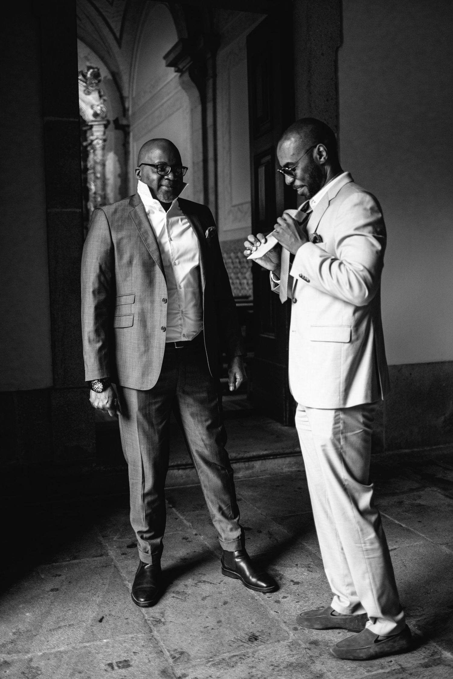 Two men in suits having an animated conversation in a black and white photograph.