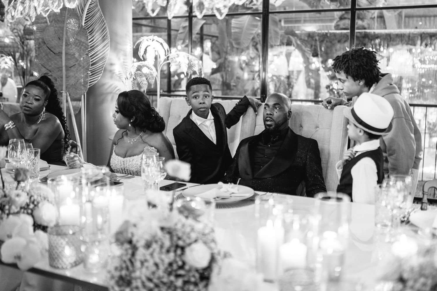 A candlelit reception dinner table with guests enjoying the celebration.