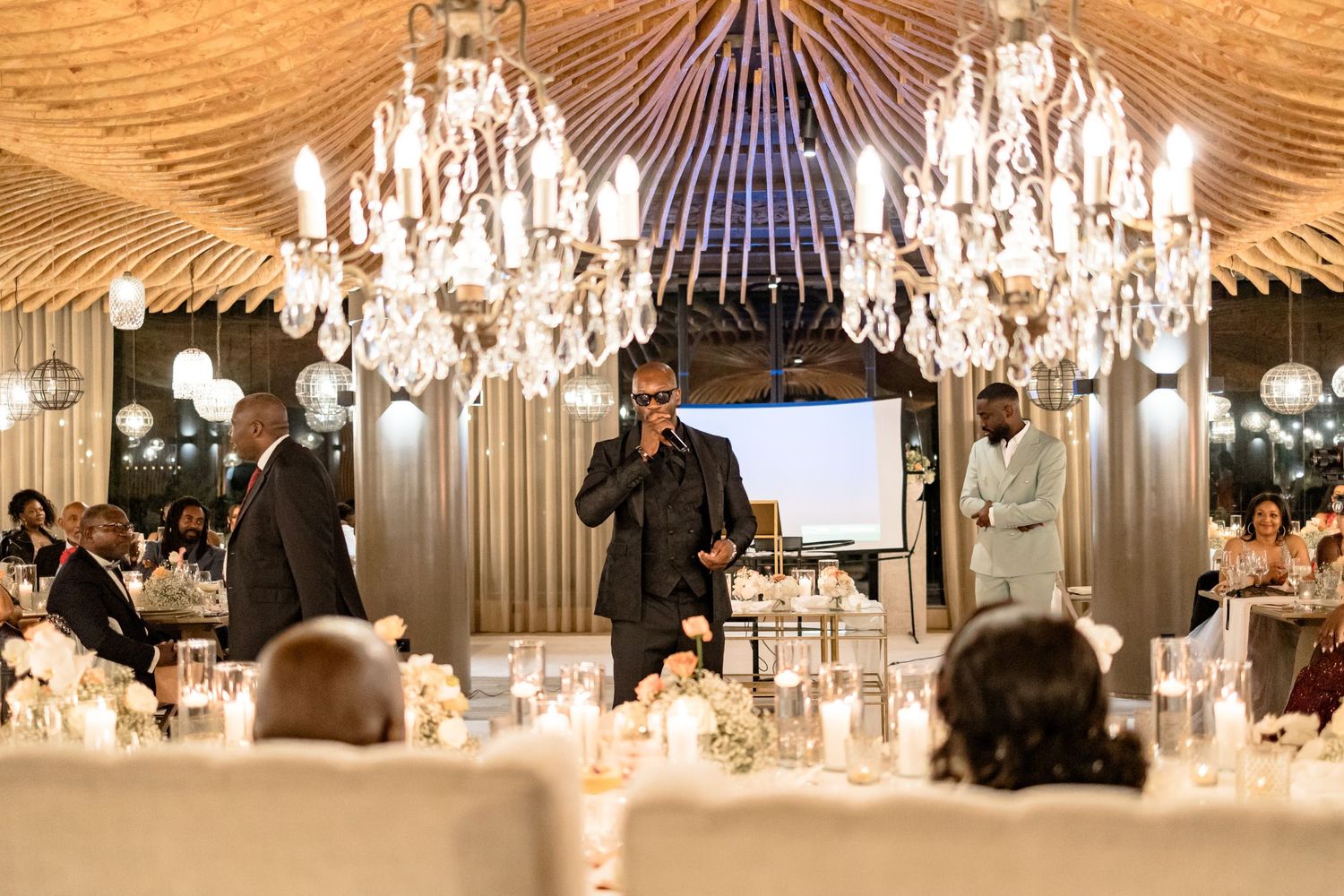 Elegant wedding reception venue with crystal chandeliers and warm ambient lighting.