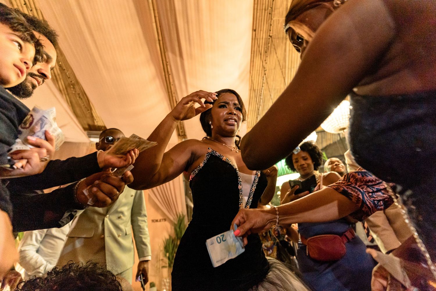 Wedding reception dance floor filled with guests celebrating under warm lighting.