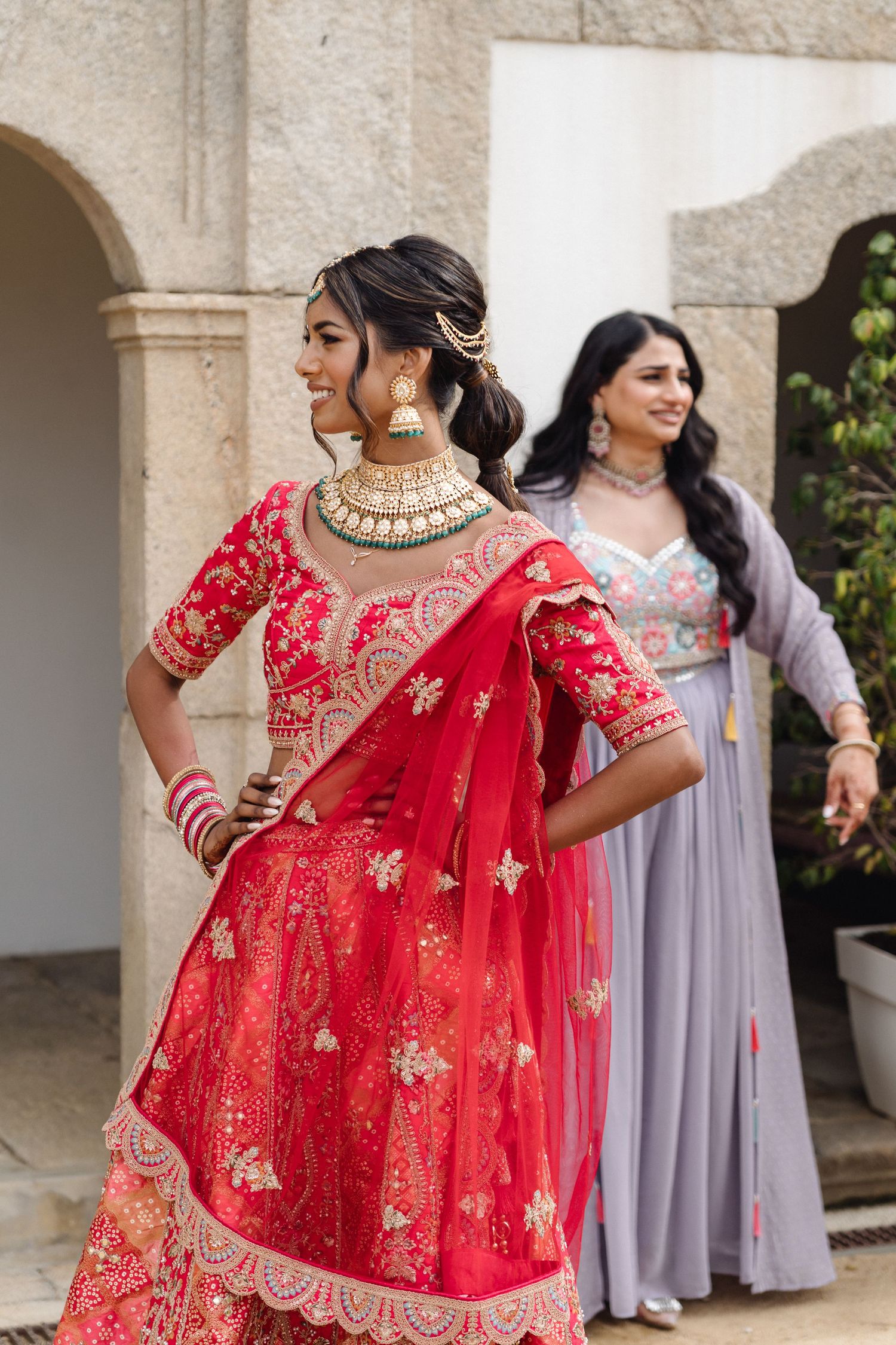 Traditional South Asian wedding attire featuring red embroidered lehenga with gold details.