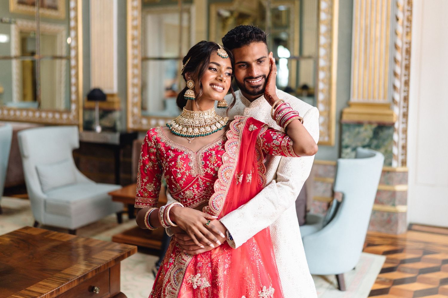 Romantic indoor wedding photos featuring red and gold traditional Indian attire.