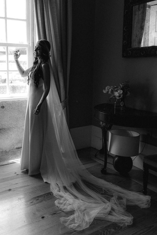 Long wedding train trailing across hardwood floor in natural window light.