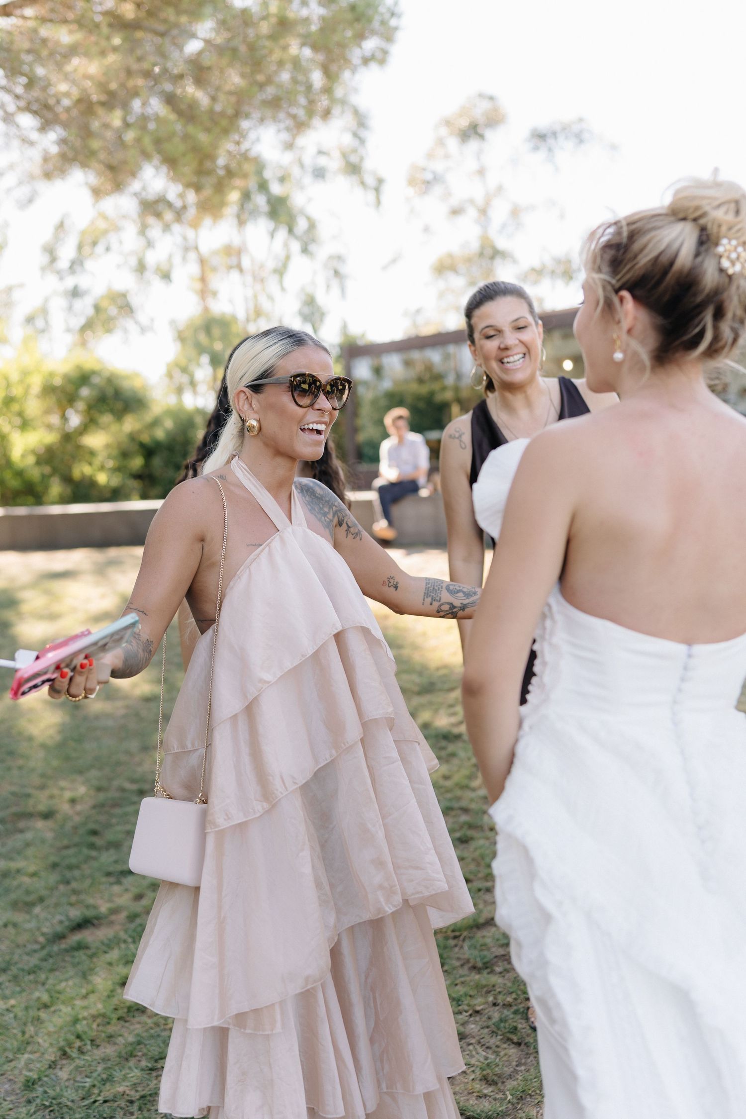 Wedding guests in formal attire share a lighthearted moment during the reception.